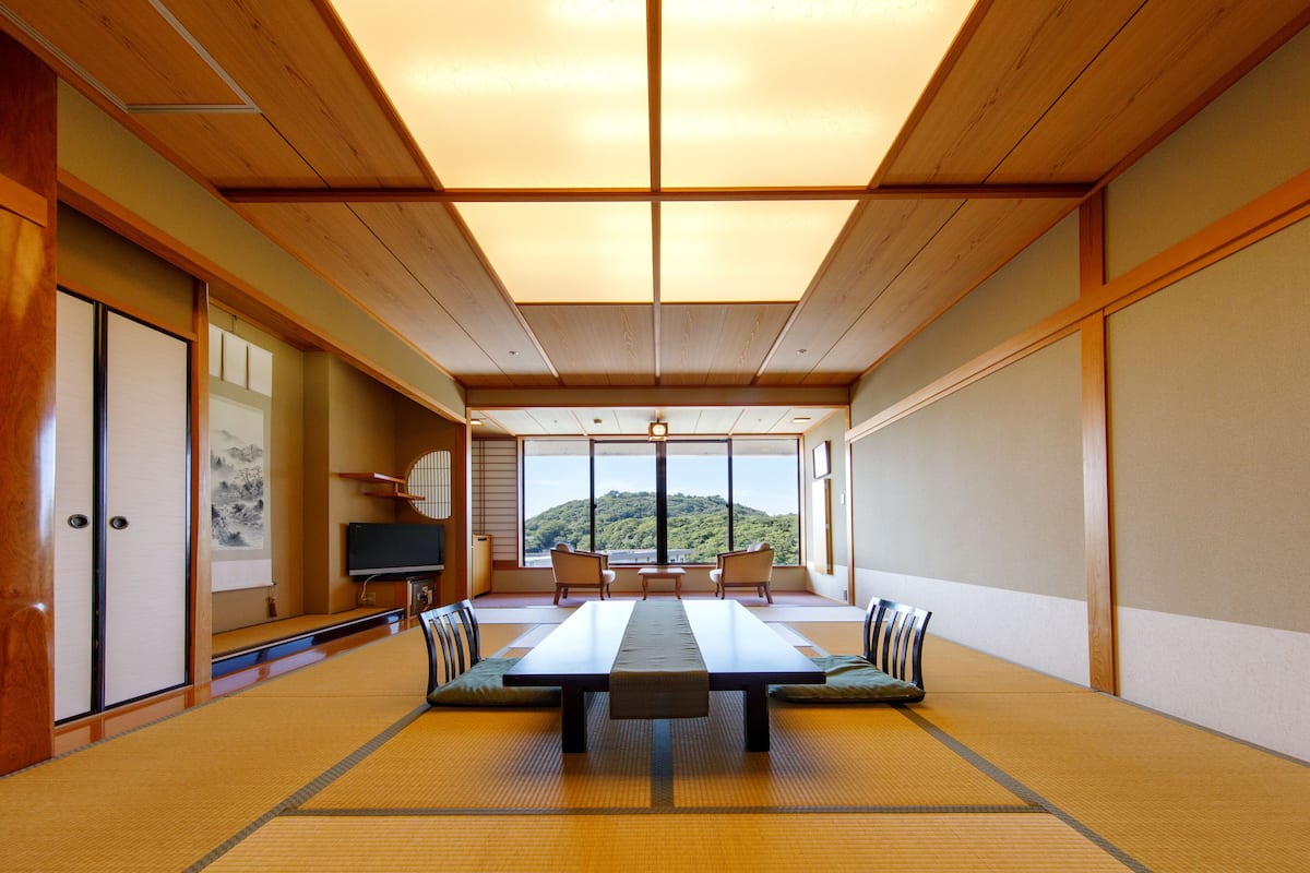 A traditional Japanese room with tatami flooring, a low table, and a television.