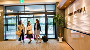 A hotel entrance with a modern design, including a glass door and a sign for HAGI KANKO HOTEL. - Hagi Kanko Hotel (Hagi)
