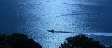 A large body of water with a boat creating a wake.