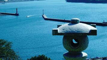 A stone balustrade overlooking a calm body of water with a pier extending into it.