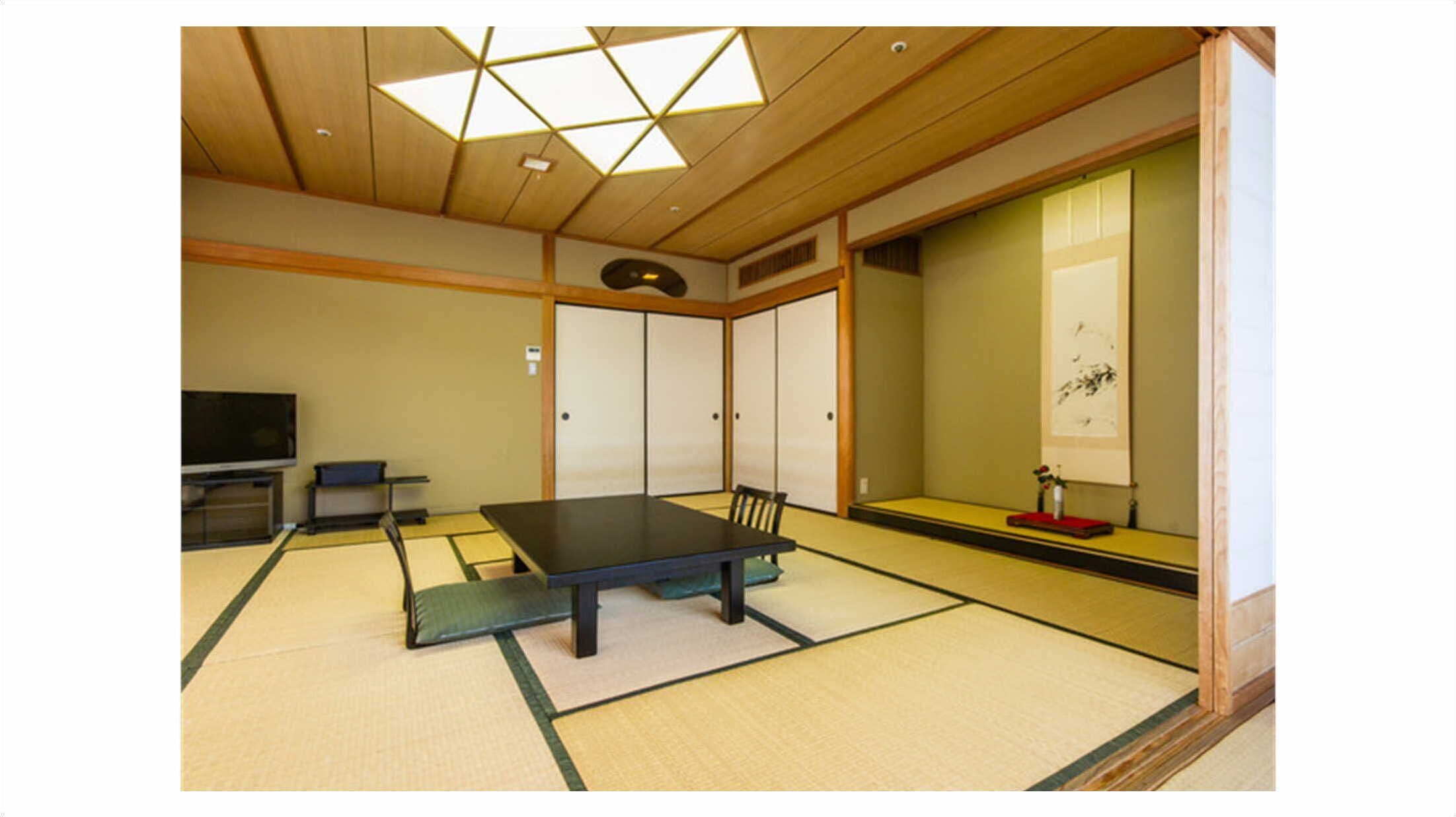 A traditional Japanese room with tatami flooring, a low table, sliding doors, and a television.