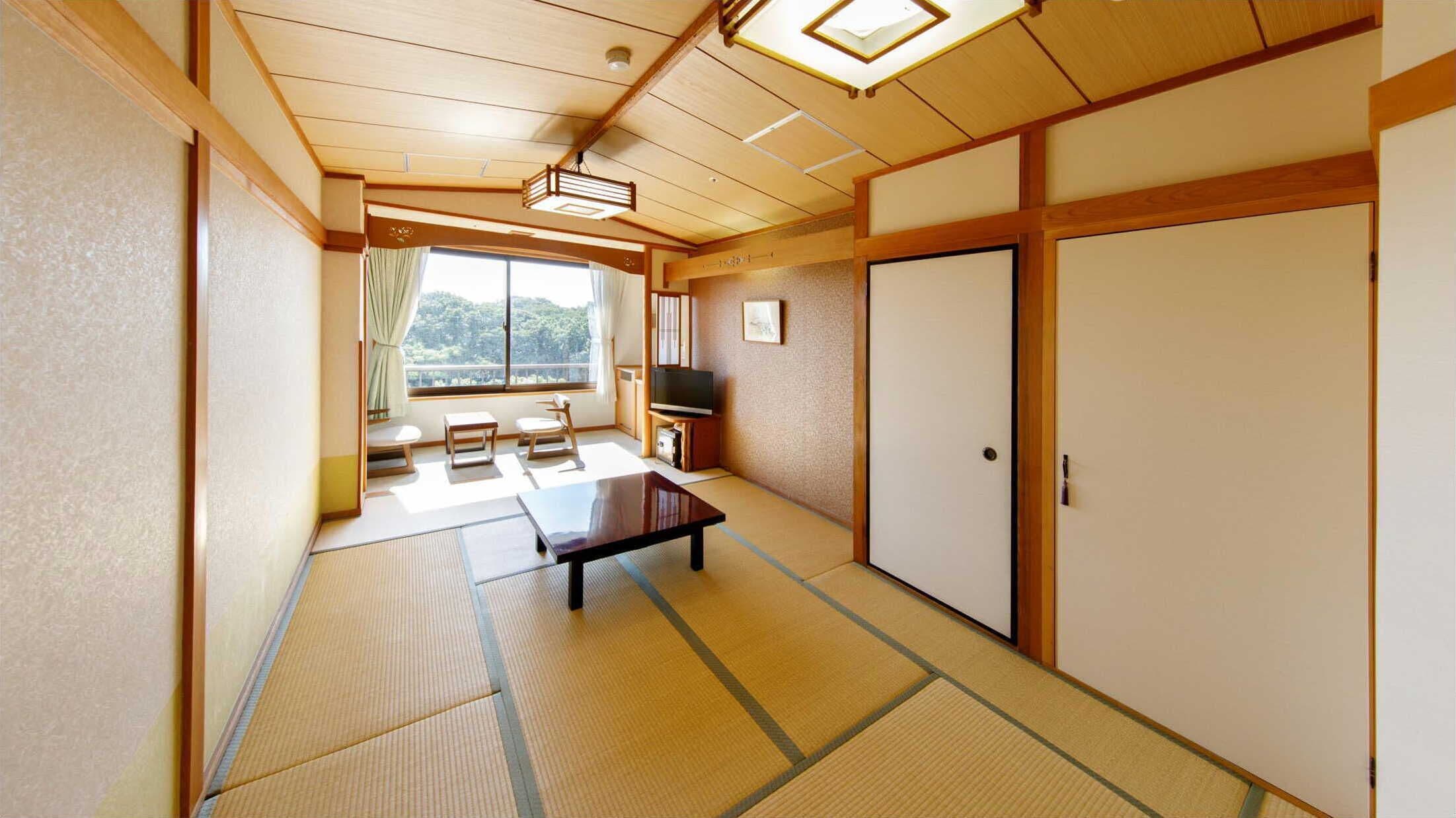 A traditional Japanese room with tatami flooring, a low table, a TV, and sliding doors.