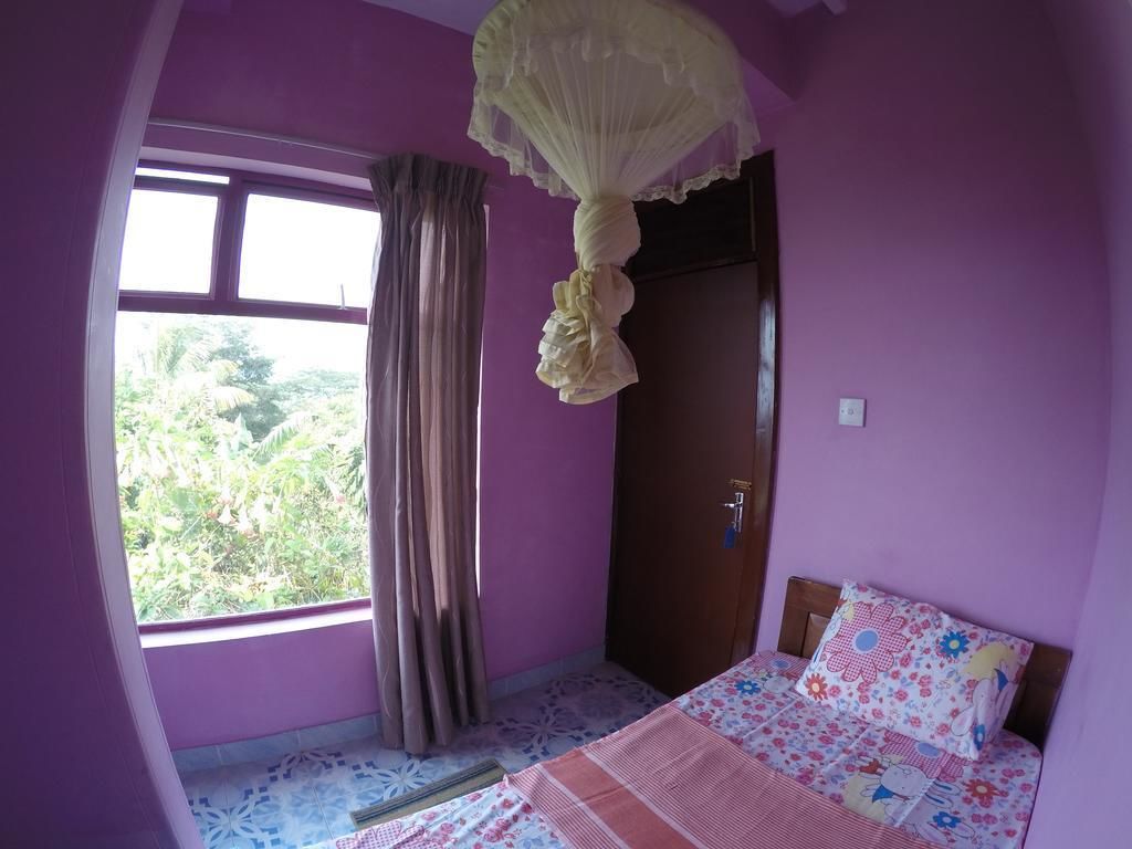 Ein Zimmer mit Bett, einem fensterbeprägtem Fenster und einer Tür.
