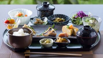 Un repas japonais traditionnel, composé de différents plats et présenté avec les ustensiles appropriés sur un plateau.