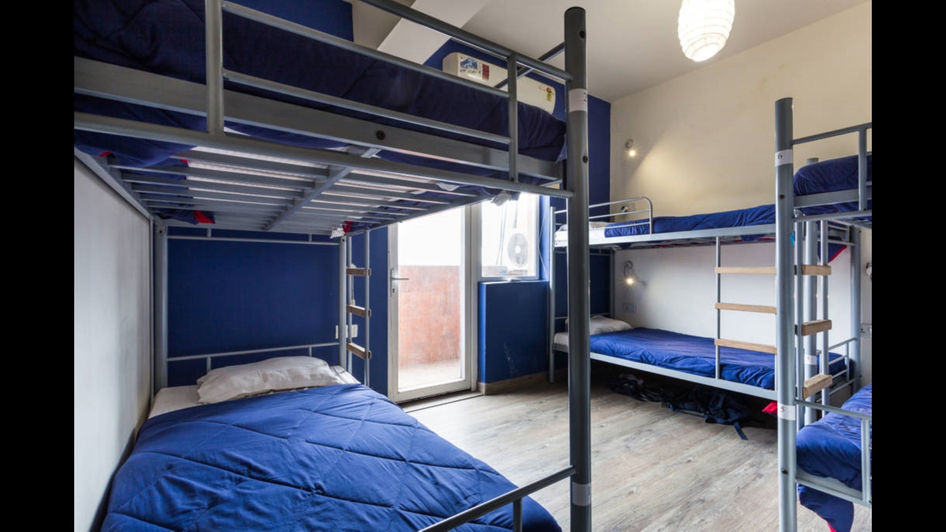Una habitació de dormitori amb literes, una finestra i una porta.