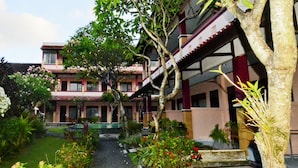 A traditional building with a garden pathway leading to the entrance. - Pesona Beach Inn (Kuta)