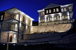 Vista frontal de la propiedad por la tarde o noche