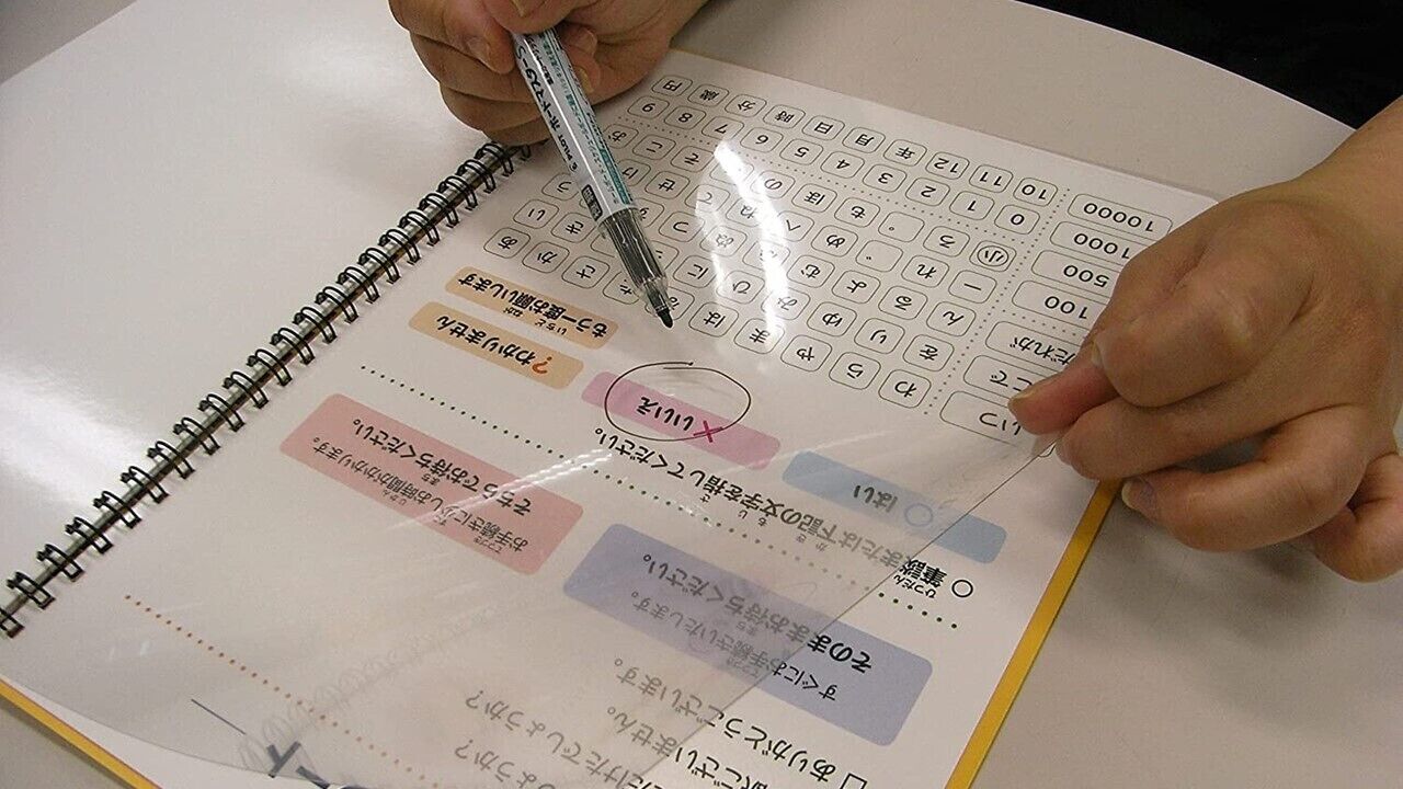 A person filling out a multiple-choice test with a pen.