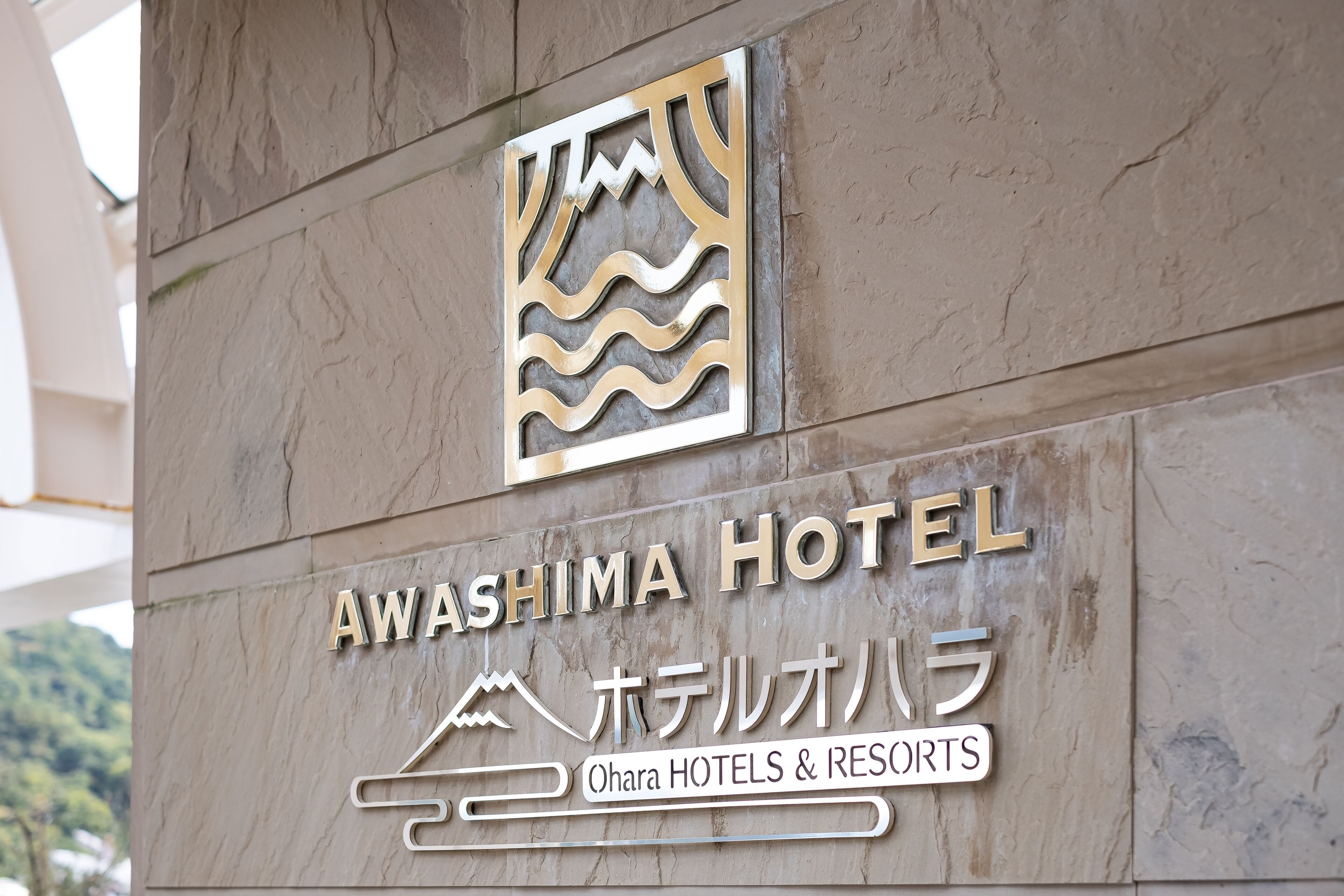 En hotellskylt med namnen ”Awashima Hotel” och ”Ohara Hotels & Resorts” på både engelska och japanska.