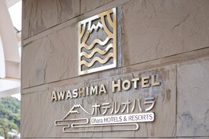 Un letrero de hotel con el nombre 'Awashima Hotel' y 'Ohara Hotels & Resorts' en inglés y japonés.