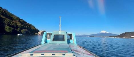 A boat with a cabin and a view of a mountain in the distance.
