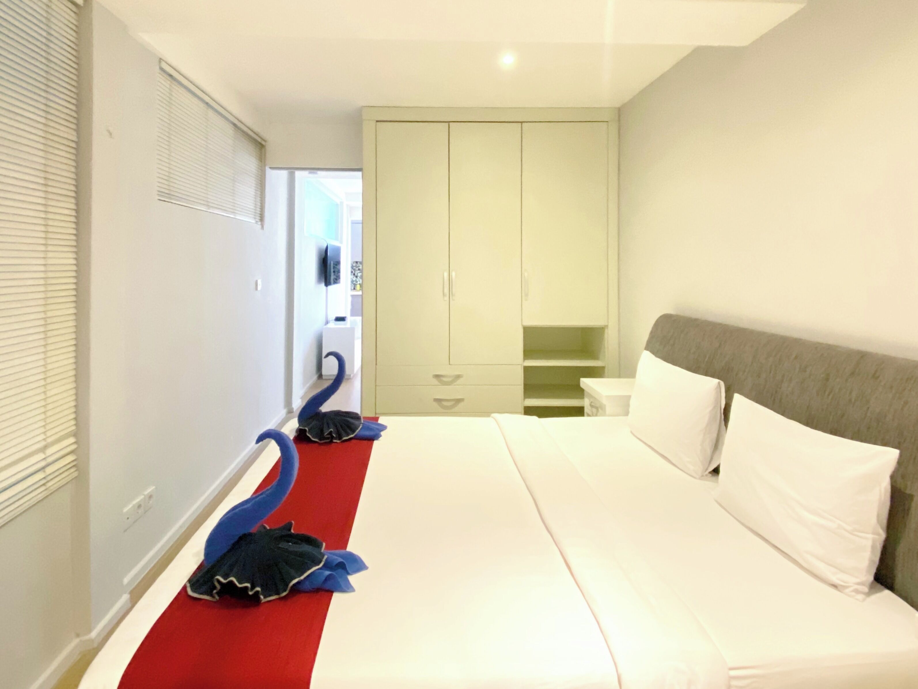 A bedroom with a bed, a wardrobe, and a red carpet.