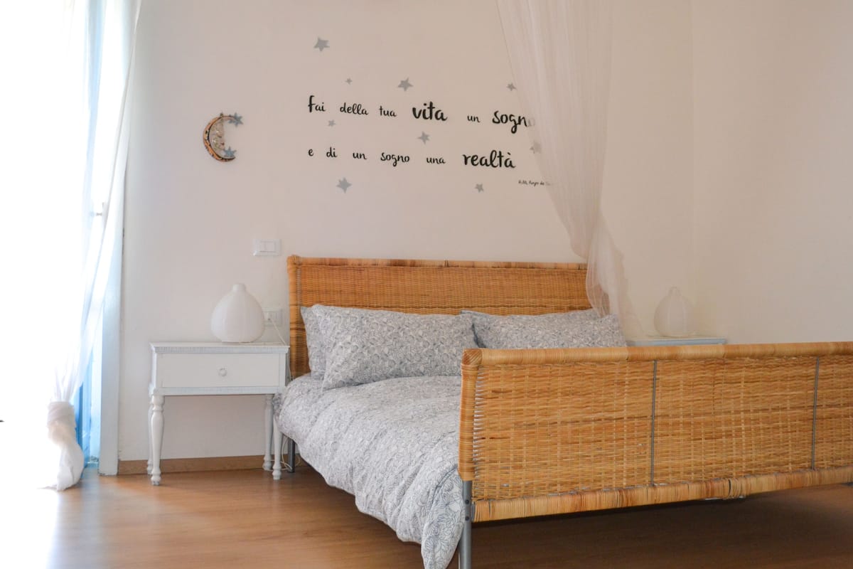 Una camera da letto con un letto, comodini e una parete decorata con scritte e stelle.