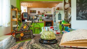 L’intérieur d’un restaurant, avec un mur vert, un présentoir à menus et un livre décoratif posé sur le comptoir.