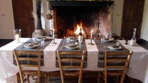 A dining table set for four with a fireplace in the background. - Podere Pievina Delle Corti (Sinalunga)