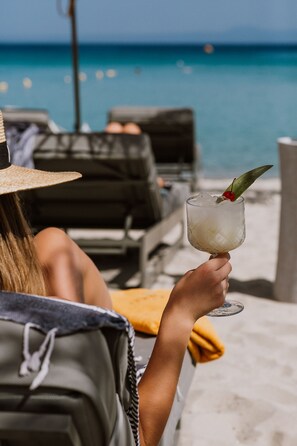 Playa privada, camastros, sombrillas y bar en la playa 