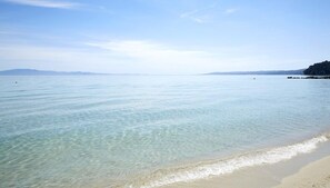 Enjoy a serene beach experience with clear waters and a sandy shoreline.