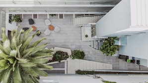 A modern outdoor area with a seating arrangement, a staircase, and potted plants.