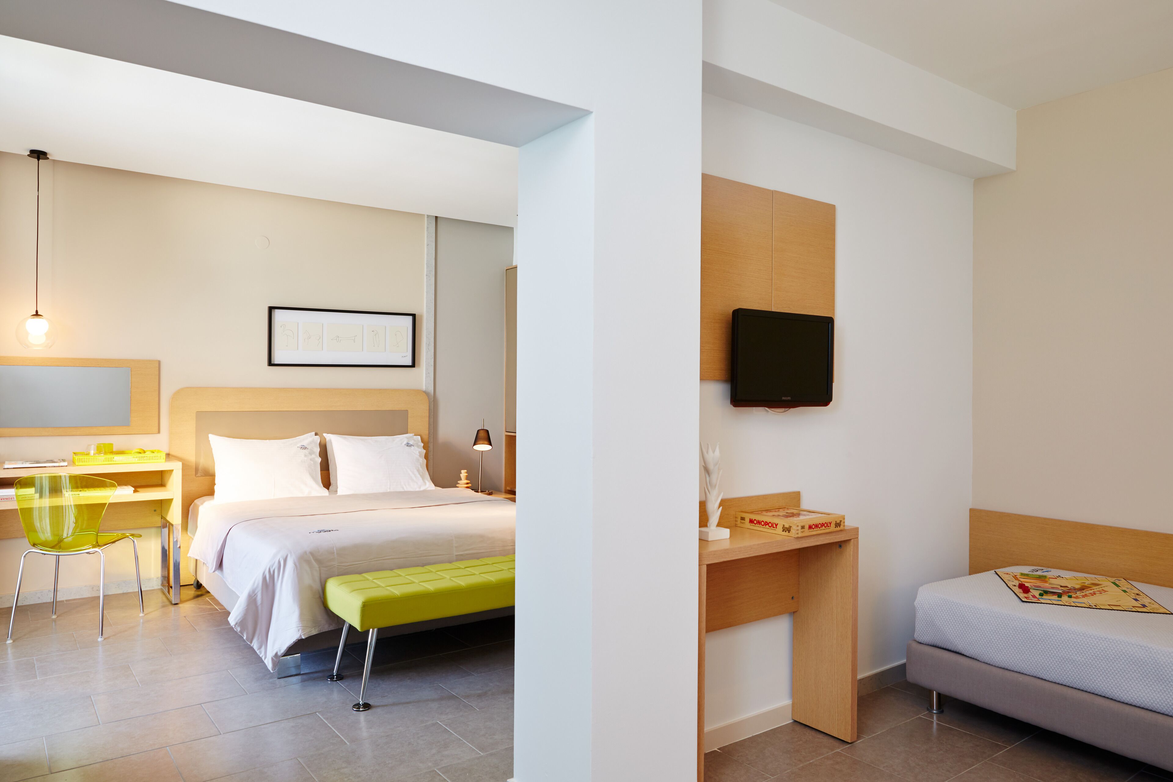 Una habitación de hotel moderna con una cama, un escritorio, una silla y un televisor.