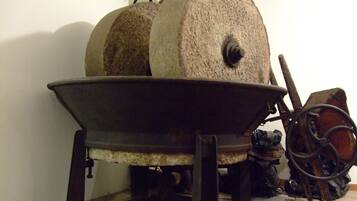 A large stone mill with a wooden wheel and a metal basin.