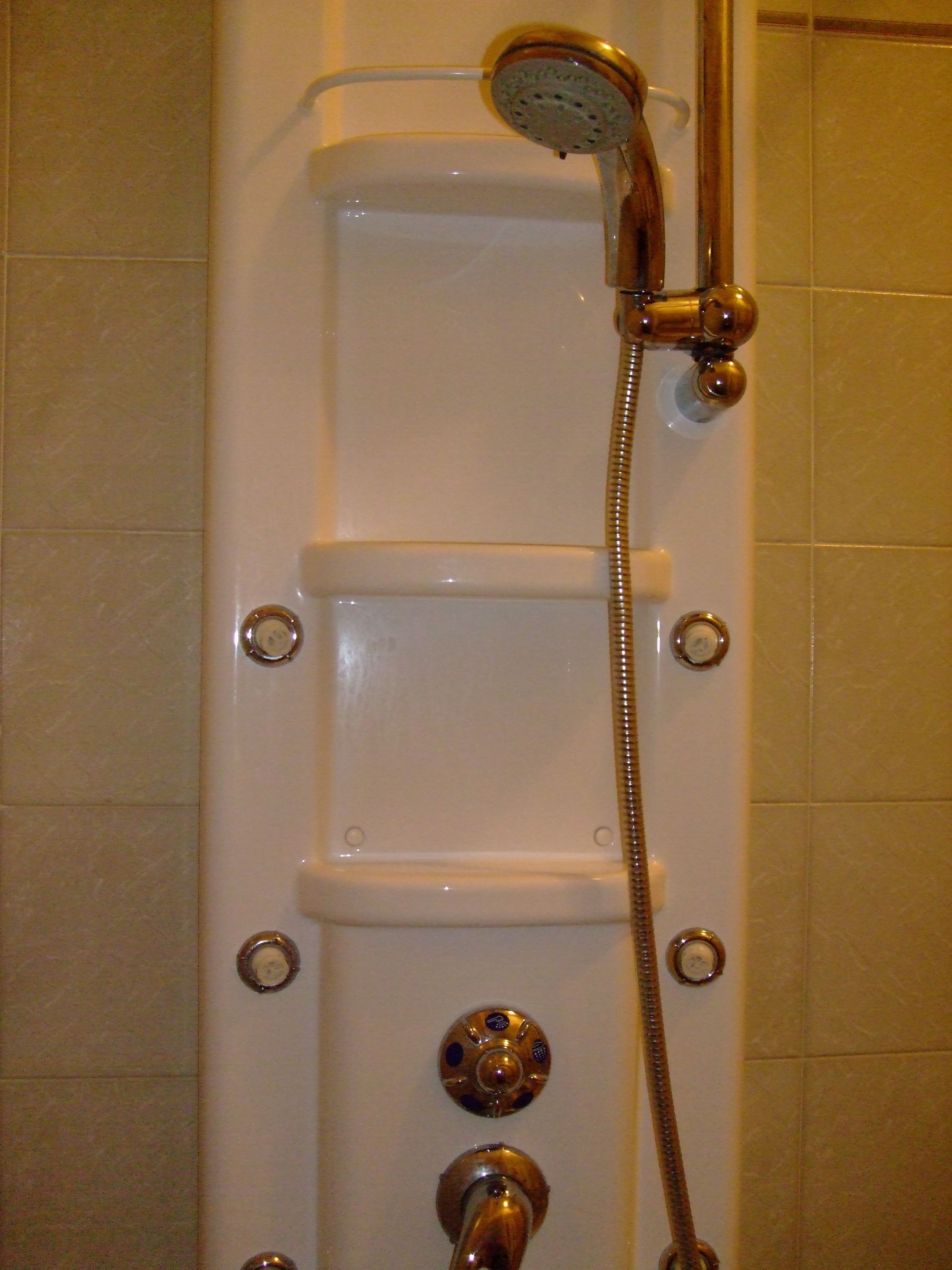 A shower with a handheld showerhead and a handheld hose.