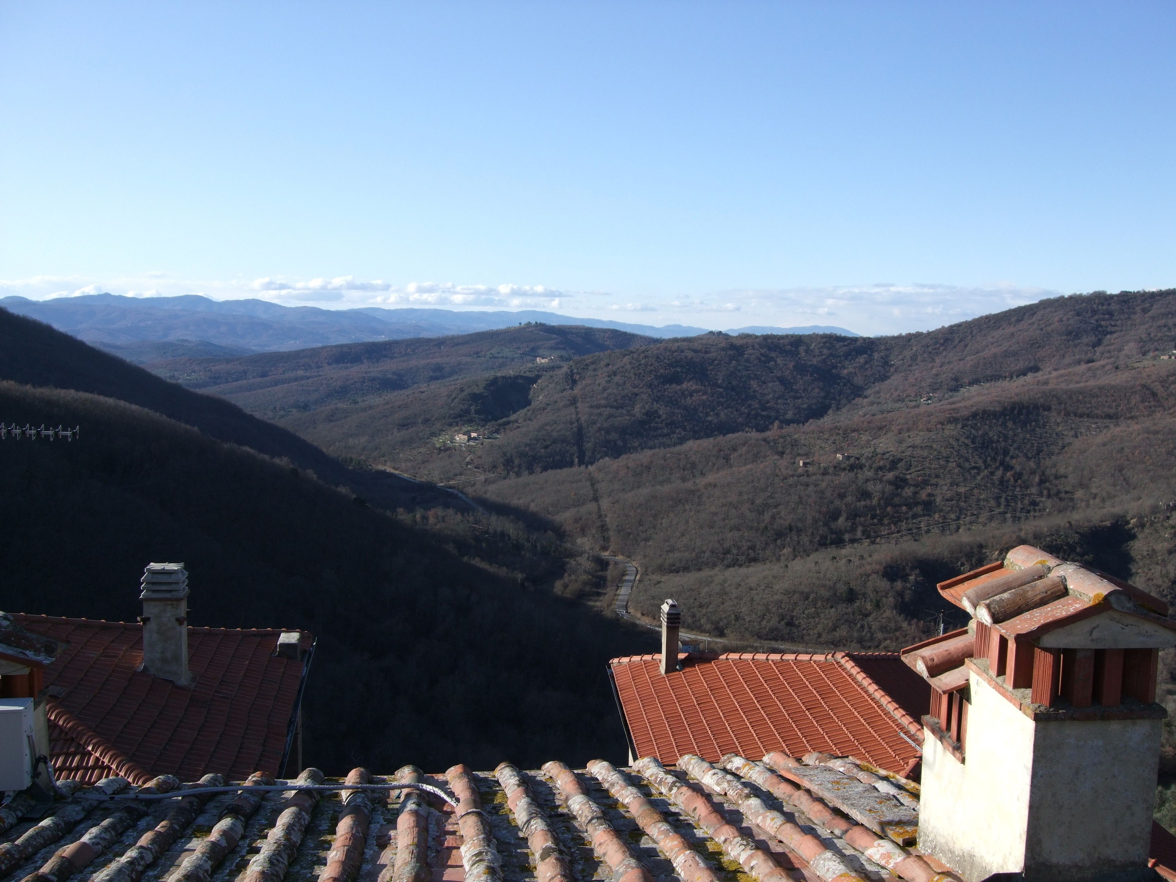 A mountainous landscape with terracotta-roofed buildings.