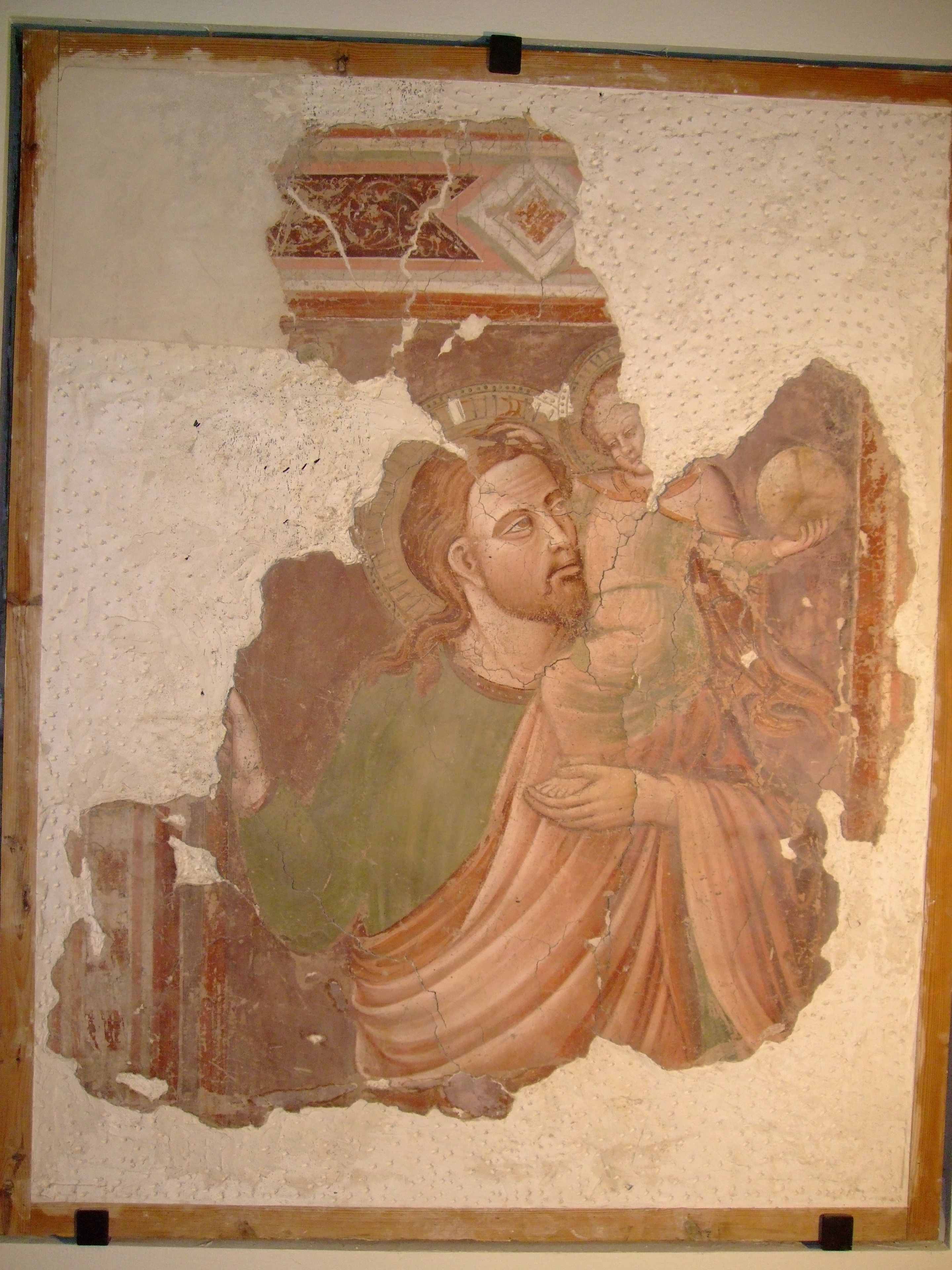 Fresco con una figura central sosteniendo a un niño, rodeado de elementos decorativos.