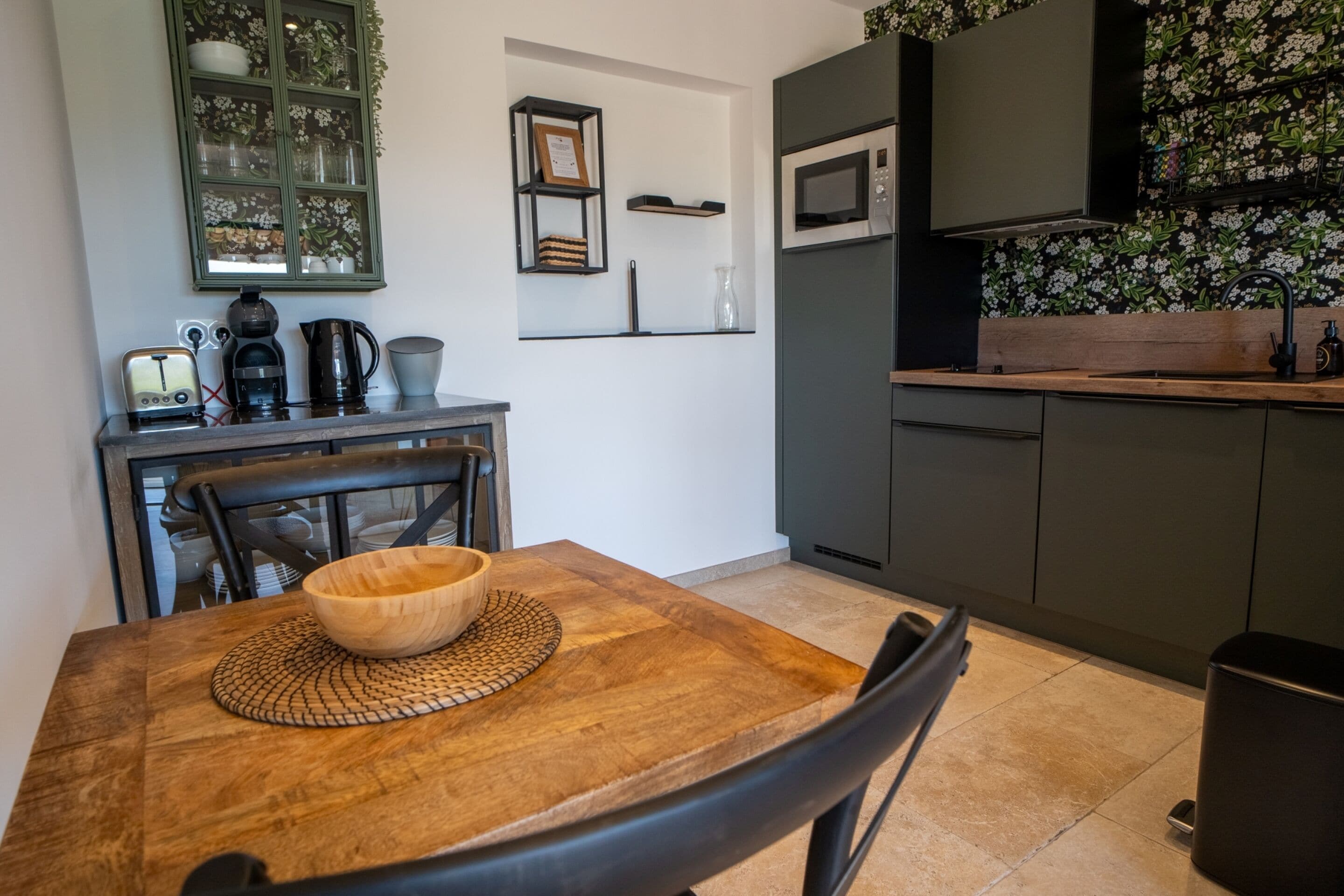 Una cocina moderna con una mesa de comedor de madera, un microondas y una cafetera.