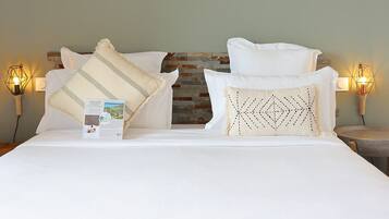 A bed with white bedding, a wooden headboard, and decorative pillows.