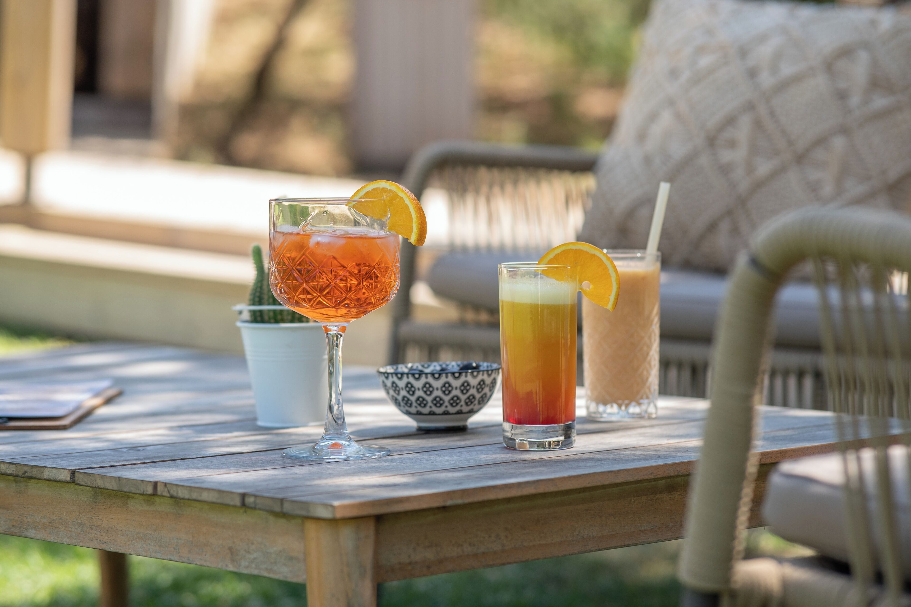 A wooden table with two drinks, a bowl, and a smartphone.