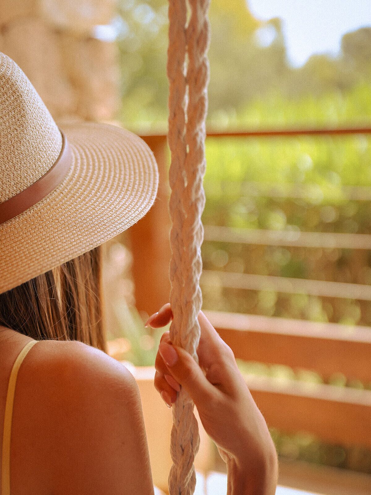 A person wearing a straw hat, holding a rope.