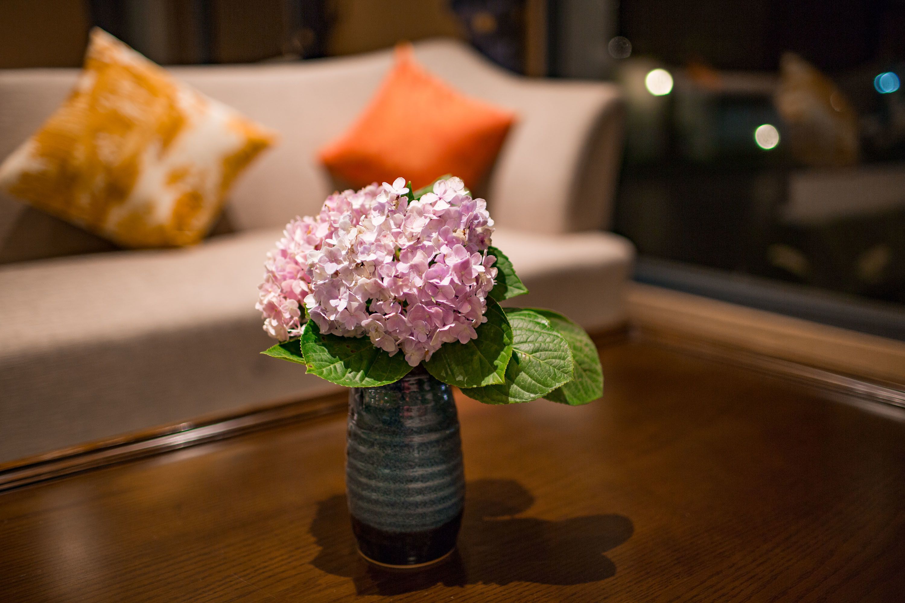 Un vase avec des fleurs roses sur une table en bois.
