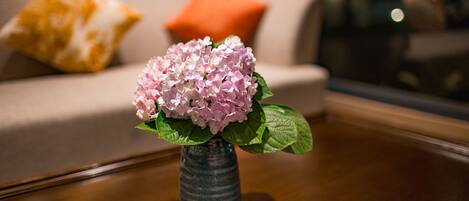 Un vase avec des fleurs roses sur une table en bois.