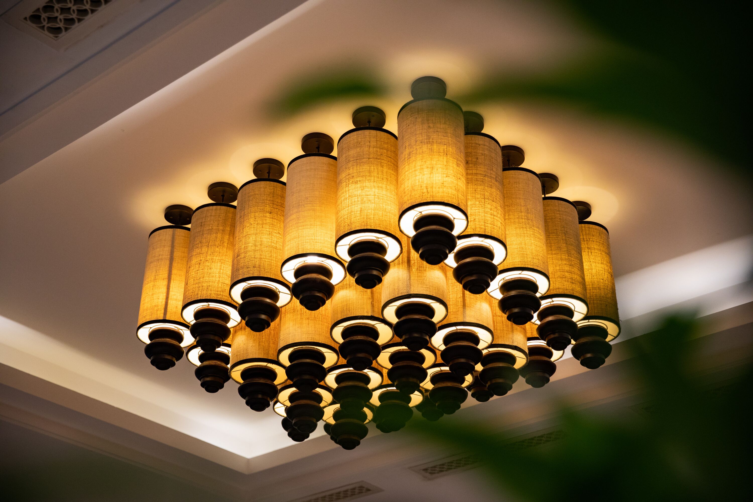 A chandelier with multiple cylindrical shades and a central light fixture.