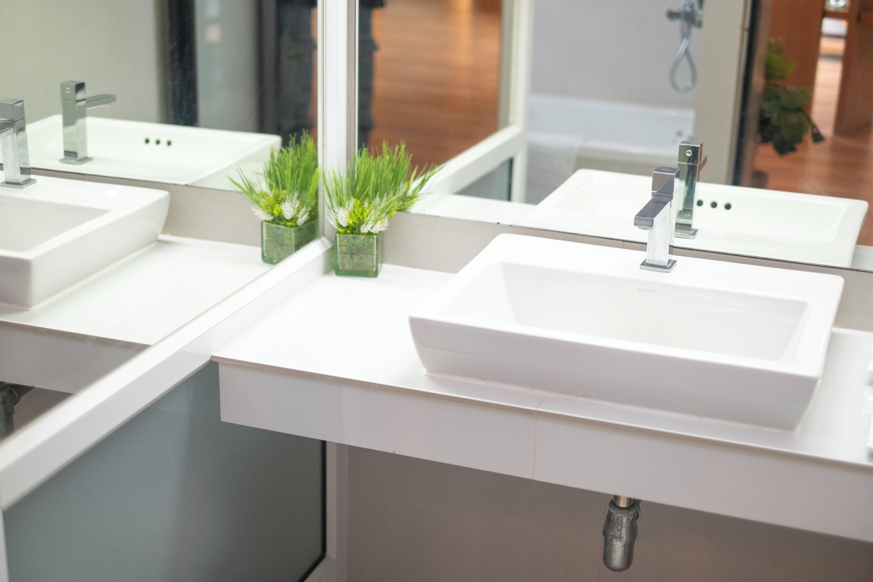 Een moderne badkamer met twee wastafels, elk met een spiegel erboven.