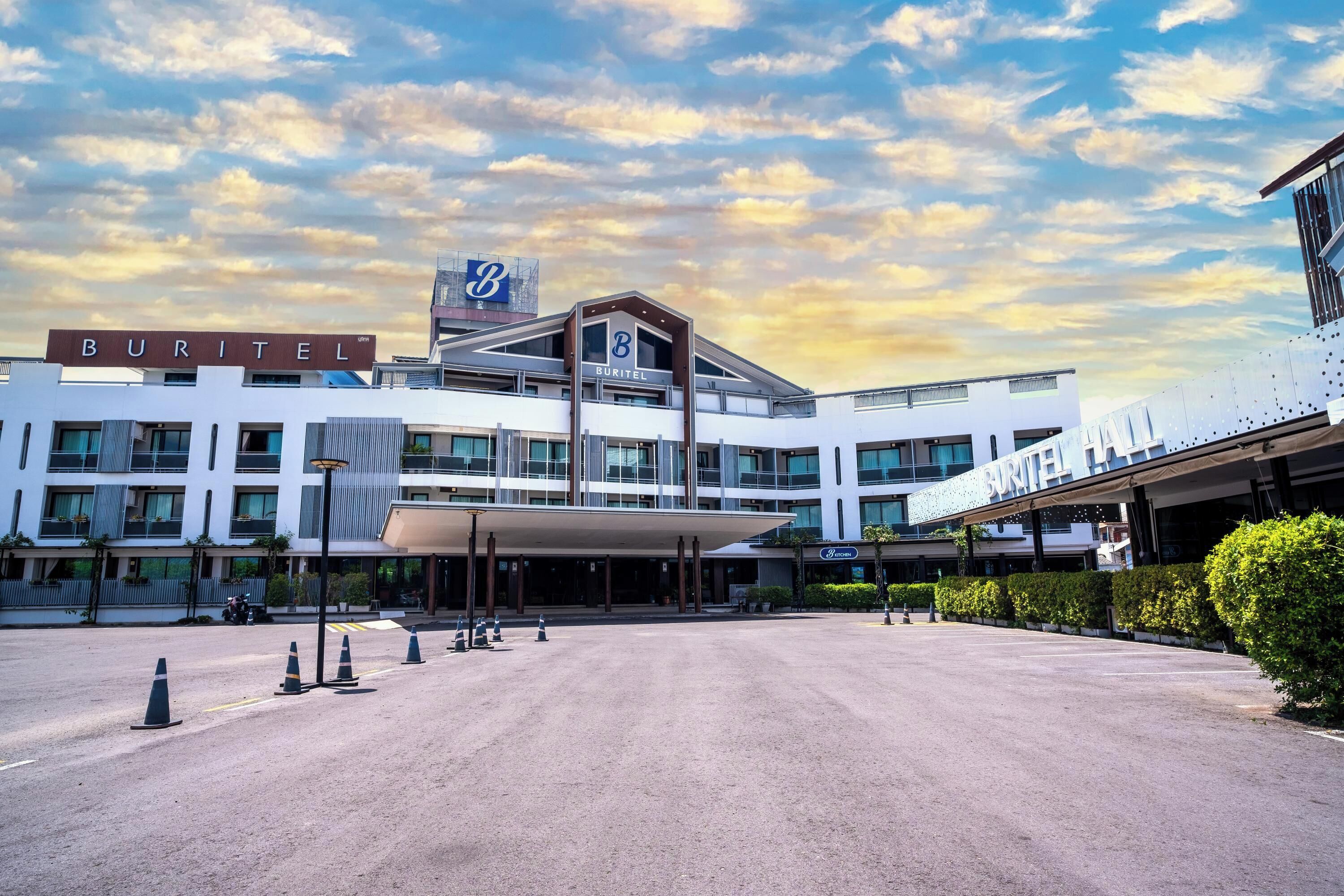 A modern hotel with a prominent 'BURITEL' sign, a spacious entrance, and a clear sky.