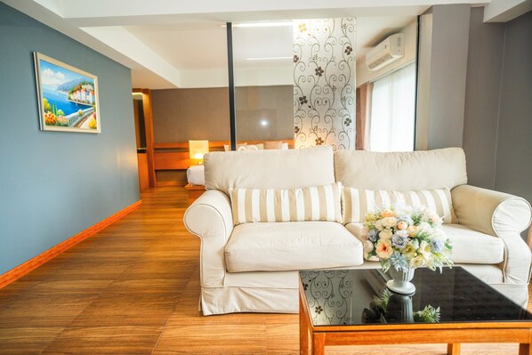 A modern living room with a sofa, a coffee table, and a painting on the wall.