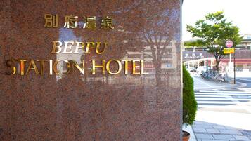 A granite sign with "BEPU STATION HOTEL" in gold lettering.
