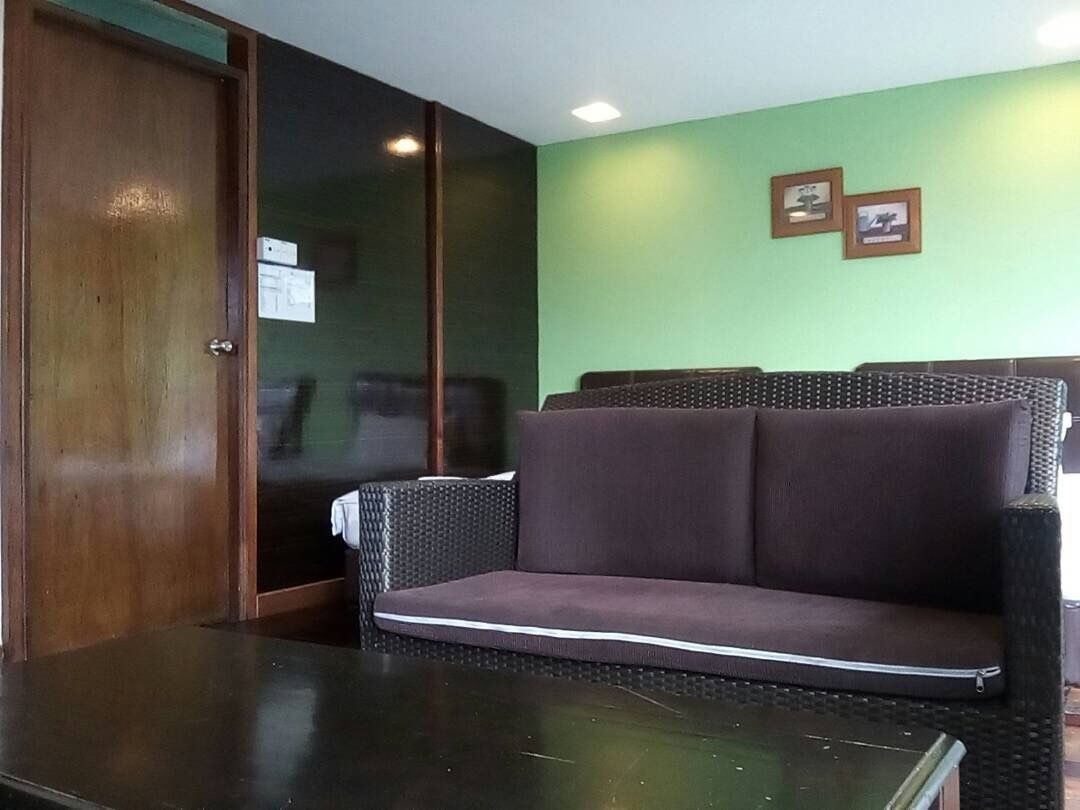 A room with a dark wooden door, a black table, and a purple sofa.