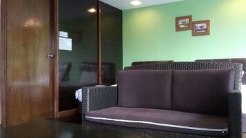 A room with a dark wooden door, a black table, and a purple sofa.