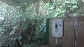 Un espace douche doté d’un panneau en verre et d’un panneau de commande numérique.