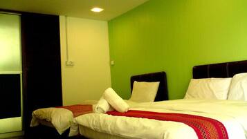 Habitación de hotel con una cama, una ventana y una pared verde.