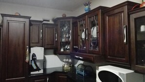 A kitchen with wooden cabinets, a microwave, and a refrigerator.