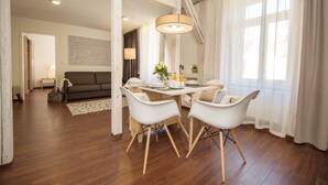 A dining area with a wooden table, white chairs, and a hanging light fixture. - Boardinghouse Luise 5 (Heidelberg)