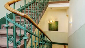 A staircase with ornate metal railings and a wooden handrail. - Boardinghouse Luise 5 (Heidelberg)