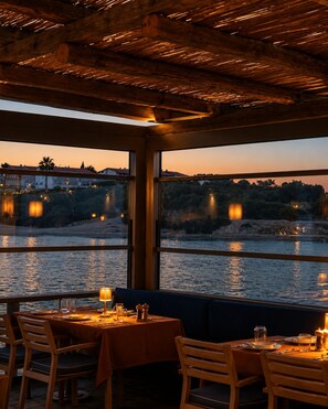 Un restaurante con vistas a un río y edificios al otro lado del agua.