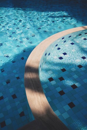 Una piscina al aire libre de temporada, sombrillas