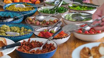 A buffet table with various food items and utensils.