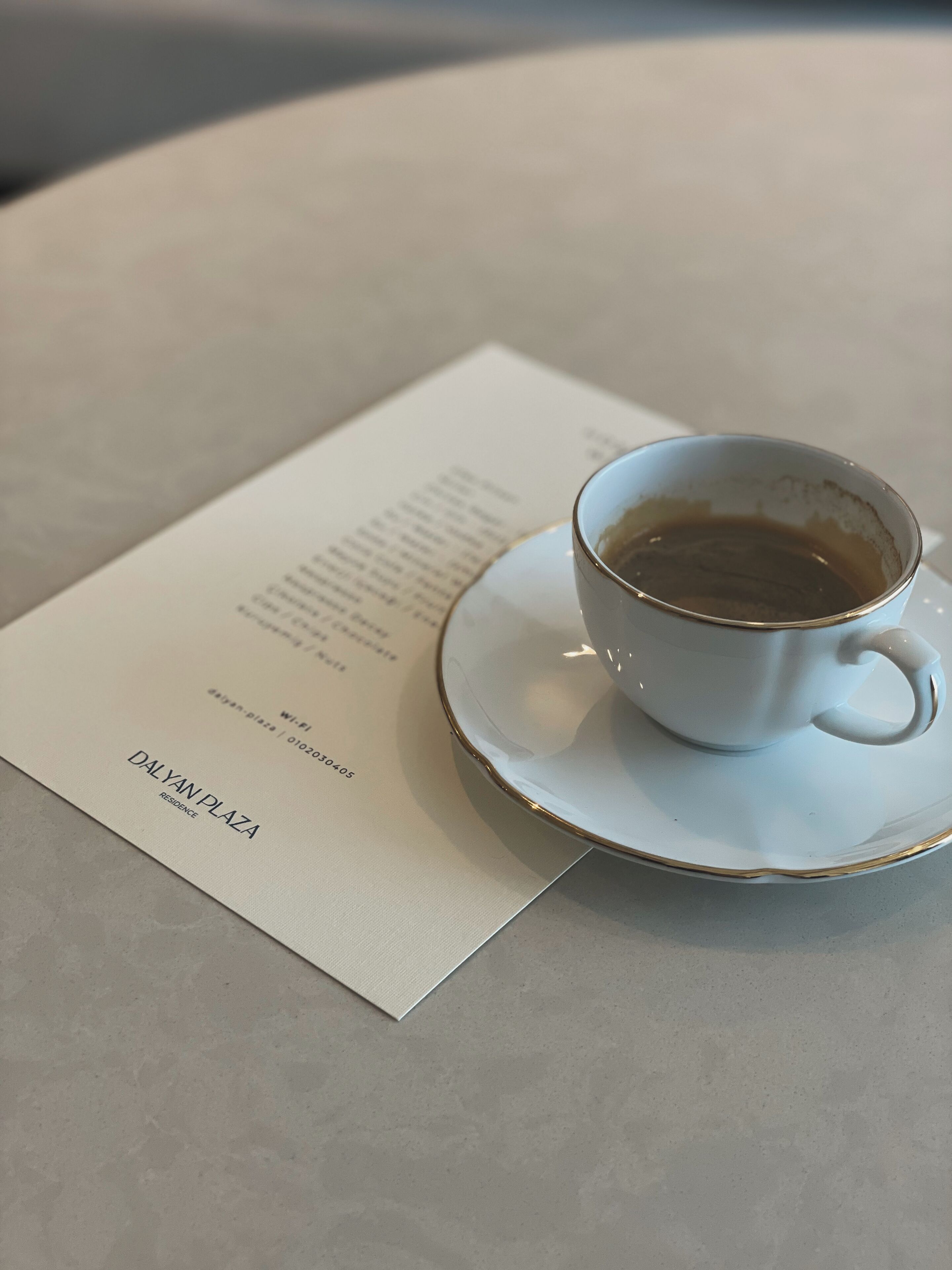 En vit kaffekopp på ett litet fat, med en meny bredvid.