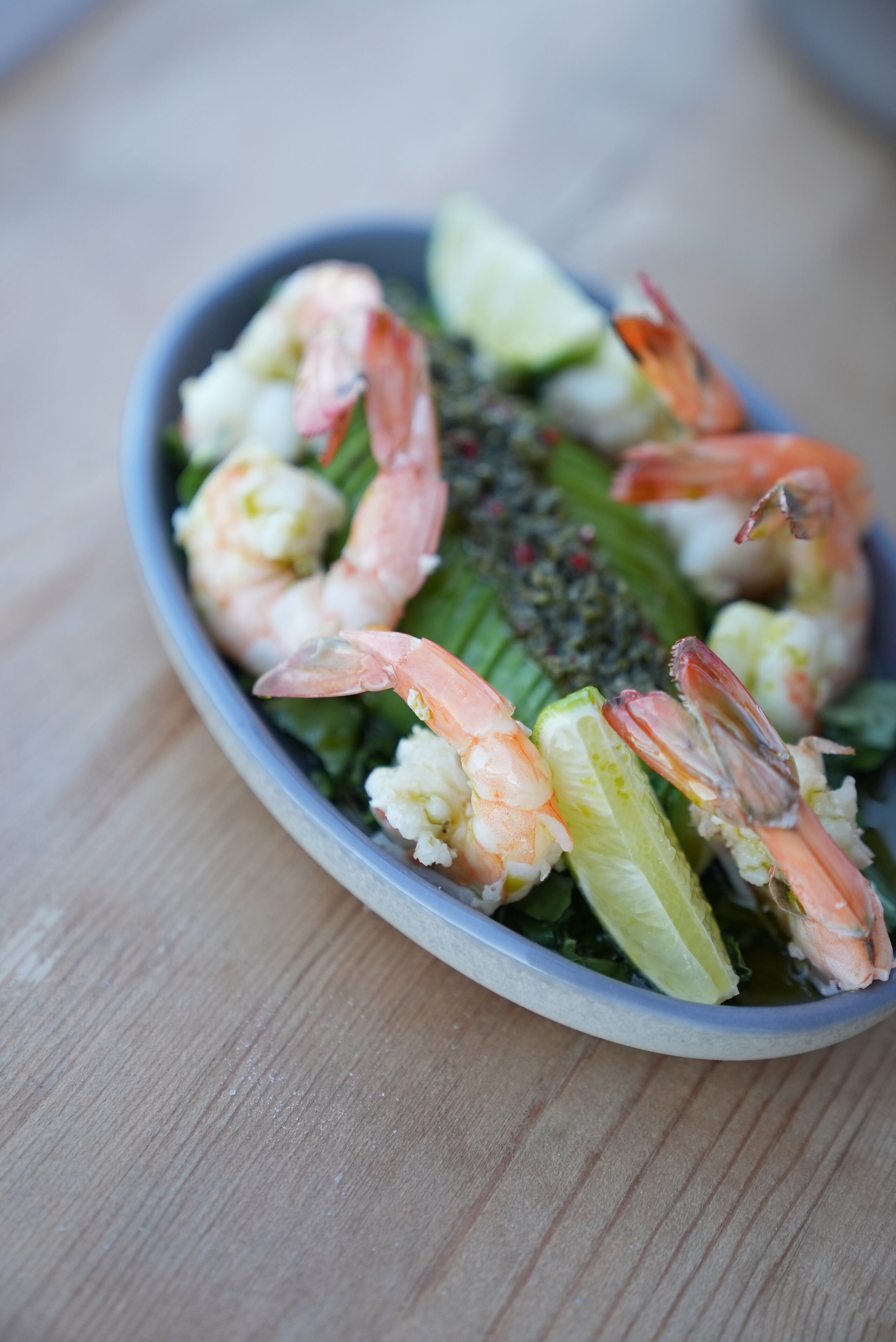 Ensalada de mariscos con camarones, lechuga y un gajo de lima.